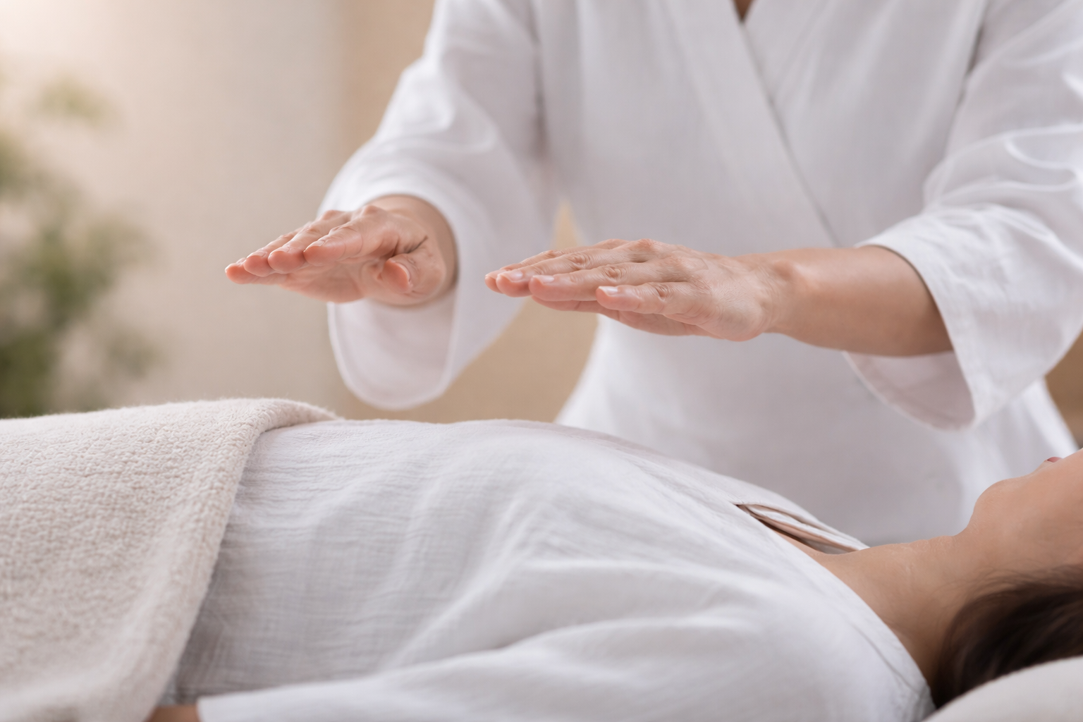A practitioner offering Reiki, hands gently positioned to channel energy